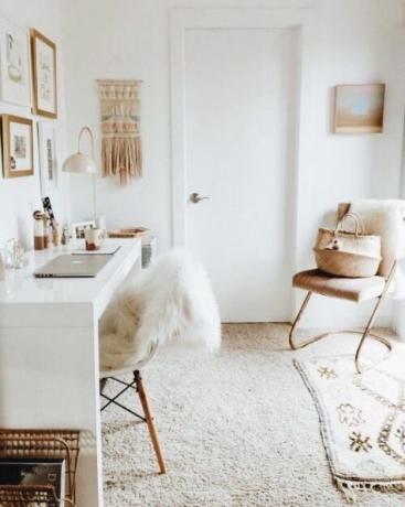 Domáca kancelária vo svetlých odtieňoch, biely leštený stôl, makramé, malý koberec, prútené predmety